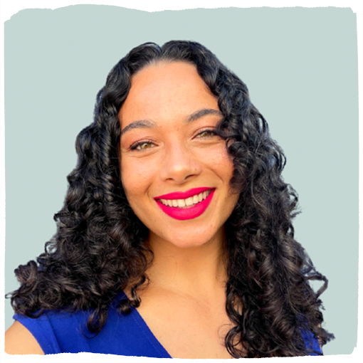 Olivia Bormann wears bright red lipstick and a royal blue shirt smiling at the camera.