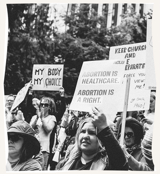 Protestors march carrying signs supporting abortion and reproductive rights.