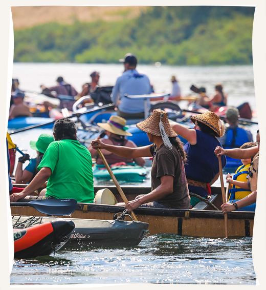 A Nimiipuu Protecting the Environment event with groups of people in boats paddling in the water